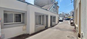 a narrow alley with buildings and a street with cars at La Galerie Pornic - Maison Cedre in Pornic