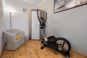 a room with a exercise bike and a chair at Apartament Frajda Zakopane in Zakopane