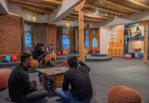 a group of people sitting in a room with a table at Black Sheep Bed & Breakfast in Kargil