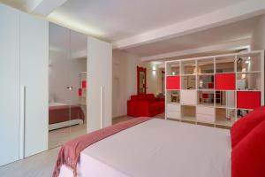 a bedroom with a large bed and a red couch at A un passo da Lucio in Bologna