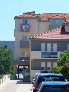 a building with cars parked in front of it at Hotel Vesna in Međugorje