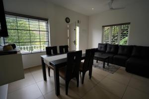 a living room with a table and chairs and a couch at Teaberg Estate Haus in Munnar