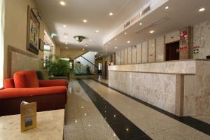 a lobby with a red couch in a building at Hotel São Lourenço in Samora Correia