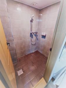 La salle de bains est pourvue d'une douche avec une porte en verre. dans l'établissement Y's house, à Séoul