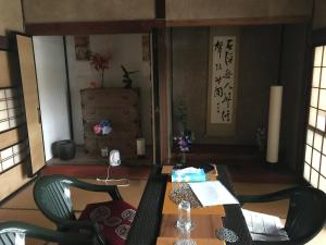 ein Wohnzimmer mit einem Tisch und einem Stuhl in der Unterkunft Kizuna no Ie in Uozu