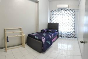 a small bedroom with a bed and a window at NurIzz Condostay Homestay Pantai Puteri Melaka in Kampong Bukit Darat