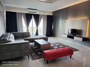 a living room with a couch and a table and a tv at NurIzz Condostay Homestay Pantai Puteri Melaka in Kampong Bukit Darat