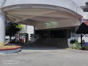 a building with stairs and a building with a roof at NurIzz Condostay Homestay Pantai Puteri Melaka in Kampong Bukit Darat