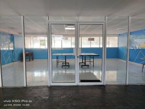 an empty room with a table and glass doors at NurIzz Condostay Homestay Pantai Puteri Melaka in Kampong Bukit Darat