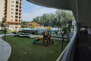 a playground with a slide in a park with a pool at NurIzz Condostay Homestay Pantai Puteri Melaka in Kampong Bukit Darat