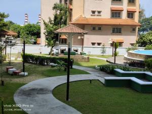 a park in front of a building with a pool at NurIzz Condostay Homestay Pantai Puteri Melaka in Kampong Bukit Darat