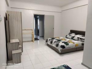 a bedroom with a bed and a tiled floor at NurIzz Condostay Homestay Pantai Puteri Melaka in Kampong Bukit Darat
