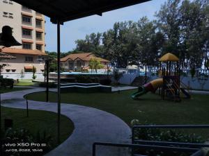 a playground with a slide in a yard with a building at NurIzz Condostay Homestay Pantai Puteri Melaka in Kampong Bukit Darat