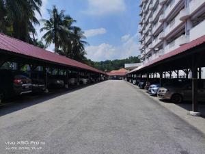 an empty street with cars parked next to a building at NurIzz Condostay Homestay Pantai Puteri Melaka in Kampong Bukit Darat
