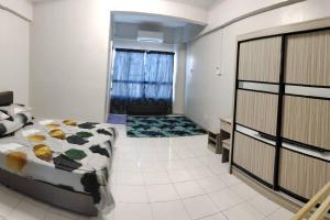 a bedroom with a bed and a large window at NurIzz Condostay Homestay Pantai Puteri Melaka in Kampong Bukit Darat