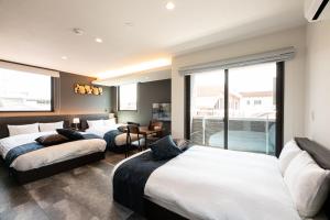 鹿児島市にあるT・Kスクエア鹿児島中央 のベッド3台とバルコニーが備わるホテルルームです。