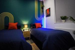 2 camas en una habitación con paredes azules y verdes en Luxury Stevenage Town Centre Apartment en Stevenage