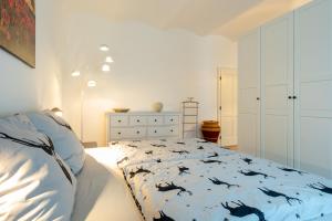 a white bedroom with a bed and a dresser at Apartment Hollenstein in Hollenstein an der Ybbs