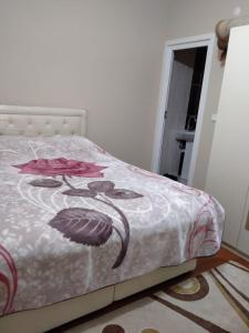 a bedroom with a bed with a floral bedspread at Şahin Apart - Demirkapı - UZUNGOL in Çaykara +6 photos