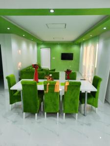 una sala de conferencias con mesa y sillas verdes en Bovan GREEN LAKE apartments en Soko Banja