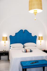 a bed with a blue headboard and a blue tray on it at Villa Mimina - Exclusive villa with garden, Jacuzzi and sea view in Praiano