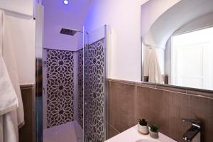 a bathroom with a shower with a mirror at Villa Mimina - Exclusive villa with garden, Jacuzzi and sea view in Praiano