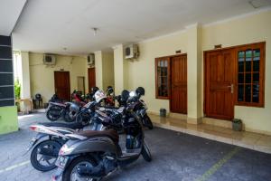 eine Reihe von Motorrädern, die vor einem Gebäude geparkt sind in der Unterkunft RedDoorz At Hotel Sartika Yogyakarta in Yogyakarta