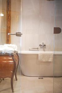 ein Badezimmer mit einer Badewanne und einem Waschbecken in der Unterkunft Boutique Hotel Virkas muiža in Kuldīga
