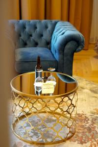 a coffee table with two bottles on it in front of a couch at Boutique Hotel Virkas muiža in Kuldīga