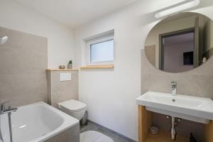 a bathroom with a sink and a toilet and a mirror at Apartmány LAMA in Nižné Malatíny