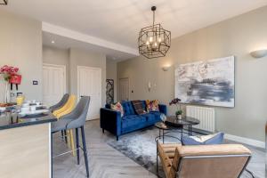 a living room with a blue couch and a table at ALTIDO Luxury flats in Old Town, right on Royal Mile in Edinburgh