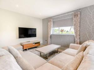 un salon avec deux canapés et une télévision à écran plat dans l'établissement Willows Cottage, à Blackburn