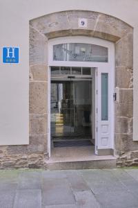 een toegang tot een gebouw met een witte deur bij Hotel Praza Quintana in Santiago de Compostela