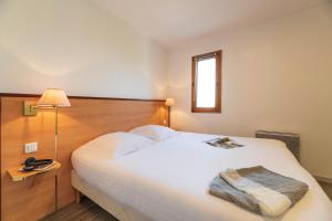 a hotel room with a bed and a lamp at Cerise Nantes La Beaujoire in Nantes