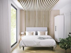 a bedroom with a white bed with a wooden ceiling at LoveSea apartments Rewal in Rewal