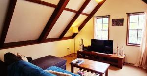 ein Wohnzimmer mit einem Sofa und einem TV in der Unterkunft Dancing Waters Cottage in Springbrook