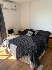 1 dormitorio con 1 cama con manta blanca y negra en Monoambiente céntrico en Santa Fe