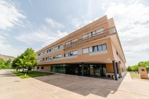 ein großes Backsteingebäude mit einem Baum davor in der Unterkunft Micampus Logroño in Logroño