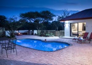 a swimming pool in a backyard at night at Sentosa Place in Hoedspruit