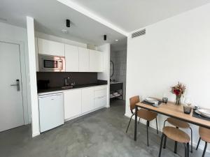 a kitchen with white cabinets and a table and chairs at HomeSanGil in Burgos