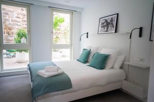 a bedroom with a bed with blue and white pillows at HomeSanGil in Burgos