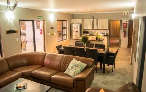 a living room and kitchen with a couch and a table at Sentosa Place in Hoedspruit