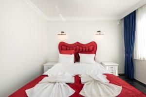Cama roja y blanca con sábanas y almohadas blancas en Stone Hause Küçük Ayasofya Mah, en Estambul