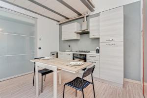 uma cozinha com uma mesa de madeira e 2 cadeiras em Honey Loft [Milano-Como-Svizzera] em Seregno