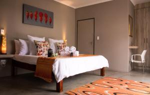 a bedroom with a bed with white sheets and pillows at Sentosa Place in Hoedspruit