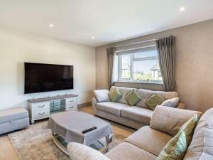 a living room with a couch and a flat screen tv at Beeches Cottage in Blackburn