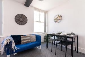 ein Wohnzimmer mit einem blauen Sofa und einem Tisch in der Unterkunft Characterful 2 bed apartment - Spacious & Comfy in Castle Donington