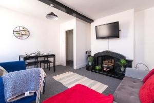 ein Wohnzimmer mit einem Kamin und einem TV an der Wand in der Unterkunft Characterful 2 bed apartment - Spacious & Comfy in Castle Donington