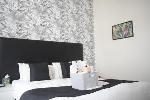 1 dormitorio con 1 cama con papel pintado en blanco y negro en The Ashleigh - Dog Friendly, en Bournemouth