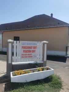 ein Schild vor einem Parkplatz mit Blumen in der Unterkunft Edit Vendégház in Tiszaújváros